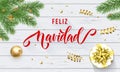 Feliz Navidad Spanish Merry Christmas holiday golden decoration and calligraphy font for greeting card white wooden background. Ve Royalty Free Stock Photo