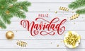 Feliz Navidad Spanish Merry Christmas holiday golden decoration on Xmas tree, calligraphy font for greeting card white wooden back Royalty Free Stock Photo