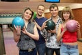 Fellows and girls stand hold balls for bowling Royalty Free Stock Photo