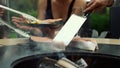 Fellows using kitchen tools outside. Unknown men cooking fish on mangal outdoors