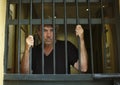 Felon in prison behind bars Royalty Free Stock Photo