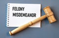 FELONY MISDEMEANOR - words in a white notebook on a gray background with a judge\'s gavel Royalty Free Stock Photo