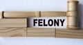 FELONY - word on the background of wooden blocks and a judge\'s gavel