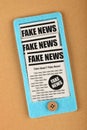 Felt craft smartphone with FAKE NEWS newspapers Royalty Free Stock Photo