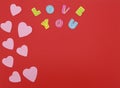 Felt hearts on red background with Love you text