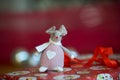 A felt mouse Christmas tree decoration sitting on a red wrapped present with silver baubles in the red background Royalty Free Stock Photo