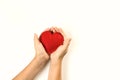 Felt red heart in childs hands on white background. View from above. Royalty Free Stock Photo