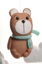 Colorful and eco-friendly children`s mobile from felt. A felt toy in the form of a lovely bear, part of a children`s mobile. On