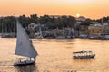 Felucca boat sailing on the Nile river at sunset in Aswan, Egypt Royalty Free Stock Photo