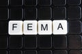 Fema control text word title caption label cover backdrop background. Alphabet letter toy blocks on black reflective background.