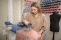 Femail Tailor using Ironing steam. The steam generator. Fashion designer ironing fabric in his studio