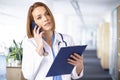 Femal doctor having a call while standing in medical clinic