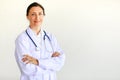 Femal doctor in white gown with stethoscope looking at camera in self-confidence manner