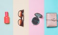 female accessories on a colored background. Sunglasses, bottle of perfume, mirror, purse. Top view. Flat lay.
