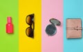 female accessories on a colored background. Sunglasses, bottle of perfume, mirror, purse. Top view. Flat lay