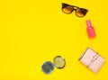 Female accessories isolated on a yellow background. Products for beauty and fashion. Sunglasses, a purse, a bottle of perfume