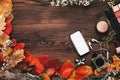 Female accessories Set. autumn leaves, smartphone and earphones on wooden background Royalty Free Stock Photo