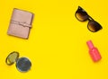 Female accessories on a yellow background. Products for beauty and fashion. Sunglasses, purse, bottle of perfume