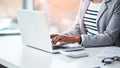 Female accountant typing on a laptop in her office or doing research on the internet while sitting at a desk. Closeup of Royalty Free Stock Photo