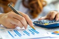 Female accountant using calculator to analyze business data and accounting records Royalty Free Stock Photo