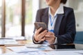 A female accountant using her smartphone at her desk. connection, internet, mobile application Royalty Free Stock Photo