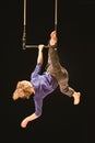 Female acrobat hanging on a swing in a circus