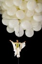 Female acrobat suspended from balloons