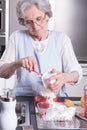 Female active pensioner is preparing strawberries Royalty Free Stock Photo