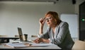 Female adjusting her glasses while reading paper records Royalty Free Stock Photo