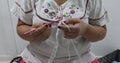 Female adult hands starting to knit a simple square pattern, making a mistake and undoing part of the knitting