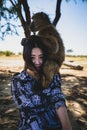 Female adult smiling happily while embracing a primate on her shoulders