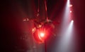 Female aerialist do stretching split on aerial silks with high heels backlit in red light. Face to the left