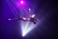 Female aerialist make flexible split on aerial hoop in air