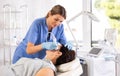 Female aesthetician administering high frequency ultrasound facial procedure on woman Royalty Free Stock Photo