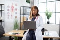 Female African American doctor working with patient's charts and records on laptop computer Royalty Free Stock Photo