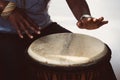 A female african musician plays the djembe drum.