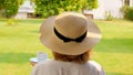 female age 50-55 in a straw hat holds a cup of hot drink and drinks coffee, sitting in the morning on a summer terrace Royalty Free Stock Photo