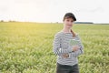 a female agronomist with a tablet checks the growth of a field with buckwheat flowers. the woman examines the field and Royalty Free Stock Photo