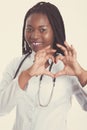 Female american african doctor, nurse woman wearing medical coat with stethoscope doing heart with hands. Happy excited for Royalty Free Stock Photo