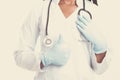 Female american african doctor, nurse woman wearing medical coat with stethoscope, mask and hand in gloves show like. Happy Royalty Free Stock Photo