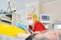 Female anesthesiologist injects anesthesia into patient face mask. General sedation while surgery operation. Paramedic putting