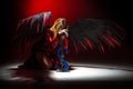 Female with angel wings praying kneeling on floor Royalty Free Stock Photo