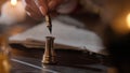 Female in antique outfit writes with feather pen. Close up shot of woman dipping vintage quill feather pen in golden Royalty Free Stock Photo