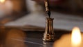 Female in antique outfit writes with feather pen. Close up shot of woman dipping vintage quill feather pen in golden Royalty Free Stock Photo