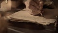 Female in antique outfit writes with feather pen. Close up shot of woman writing a letter with vintage quill on old Royalty Free Stock Photo