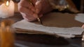 Female in antique outfit writes with feather pen. Close up shot of woman writing a letter with vintage quill on old Royalty Free Stock Photo