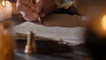 Female in antique outfit writes with feather pen. Close up shot of woman writing a letter with vintage quill on old Royalty Free Stock Photo