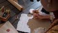 Female in antique outfit writes with feather pen. Over shoulder shot of woman writing a letter with vintage quill Royalty Free Stock Photo