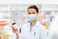 Female apothecary in mask with drug at pharmacy Royalty Free Stock Photo