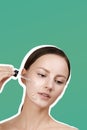 Female applying anti wrinkle serum on skin face, looks down, brown hair gathered in a low ponytail Royalty Free Stock Photo